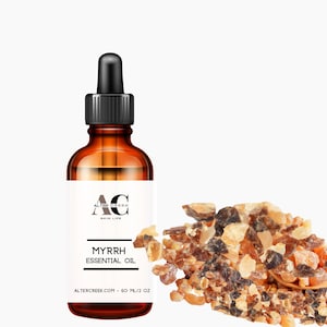 May include: A brown glass bottle with a dropper top filled with Myrrh Essential Oil. The bottle label is white with black text that reads "Alter Creek Skin Love" and "Myrrh Essential Oil". The bottle is sitting on a white background with a pile of brown and yellow myrrh resin in the foreground.