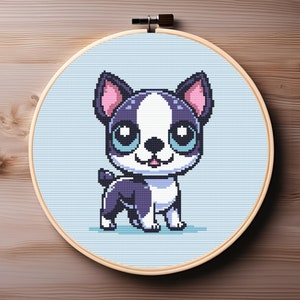 May include: Cross stitch pattern of a cartoon Boston Terrier dog with big blue eyes and a pink nose. The dog is standing on a light blue background.