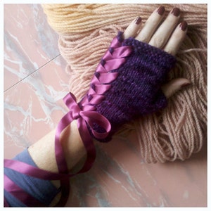 May include: Purple knitted fingerless gloves with a pink satin ribbon tied around the wrist.