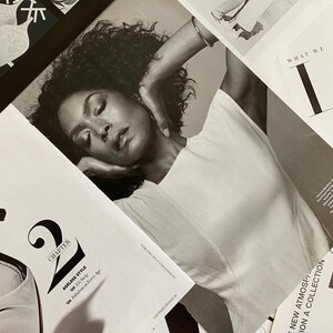 Puede incluir: Una doble p&aacute;gina de revista en blanco y negro con una mujer de pelo rizado que lleva una camisa blanca. El texto de la p&aacute;gina dice "Cap&iacute;tulo 2, Estilo atemporal, 126 Lis Sarig, 128 Fabulosa a cualquier edad".