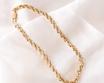 May include: A gold-toned chain bracelet featuring a series of interconnected round links. The bracelet is secured with a small lobster claw clasp at one end, providing a simple and functional design for this piece of jewellery.