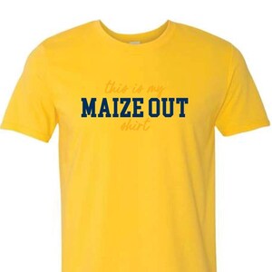 May include: Yellow t-shirt with the text "This is my MAIZE OUT shirt" in navy blue and orange lettering.