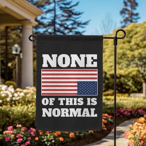 May include: Black garden flag with the text "NONE OF THIS IS NORMAL" in white block letters. The flag features an American flag design in the center. The flag is hanging on a black metal pole in a garden.