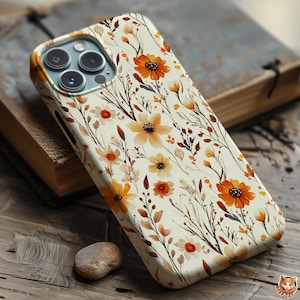 May include: A phone case with a floral design featuring orange and yellow flowers, brown stems, and green leaves on a cream background. The case is made of a hard, protective material.