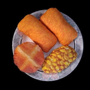 May include: A plate with four plush food items. Two rectangular, orange-colored items, a round, orange item with a cross design, and an oval-shaped item with yellow and brown details. The plate has a floral design.