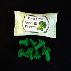 May include: A green felt bag with the text "Farm Fresh Broccoli Florets" printed on it. The bag is filled with green felt broccoli florets.