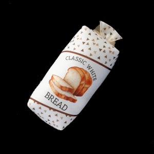 May include: A white bread bag with a brown triangle pattern. The bag has a label that says "Classic White Bread" with a watercolor illustration of sliced white bread.