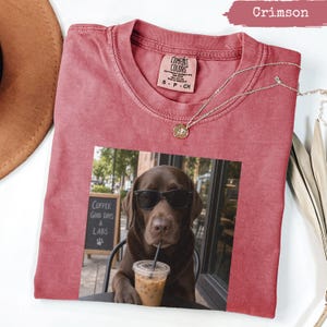Crimson t-shirt with dog wearing sunglasses and holding iced coffee.