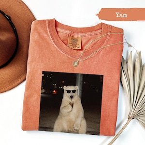 T-shirt with a polar bear wearing sunglasses drinking from a cup.