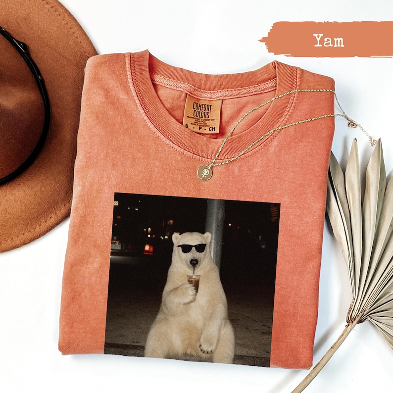 T-shirt with a polar bear wearing sunglasses drinking from a cup.