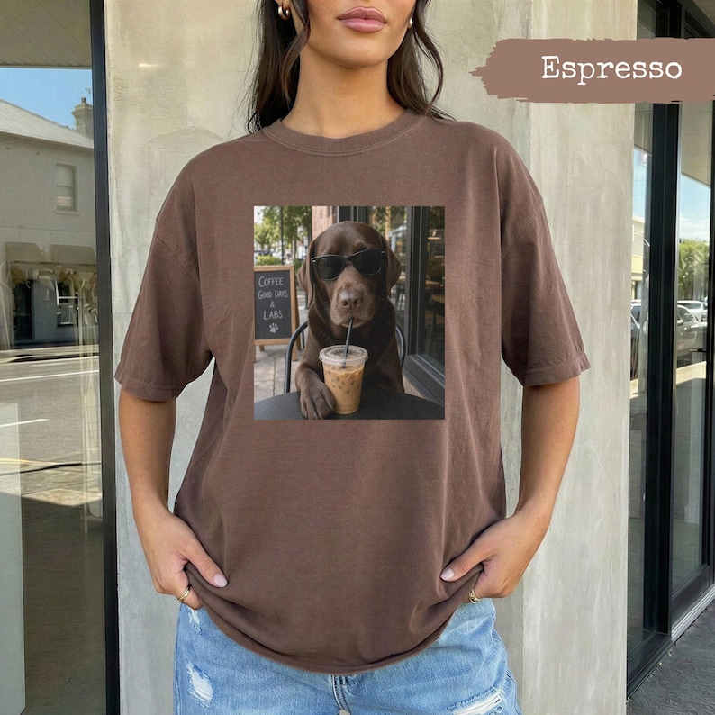 Brown t-shirt with a chocolate lab wearing sunglasses holding an iced coffee.