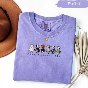 Purple t-shirt with "Just a Spooky Cow" text and Halloween-themed cows.