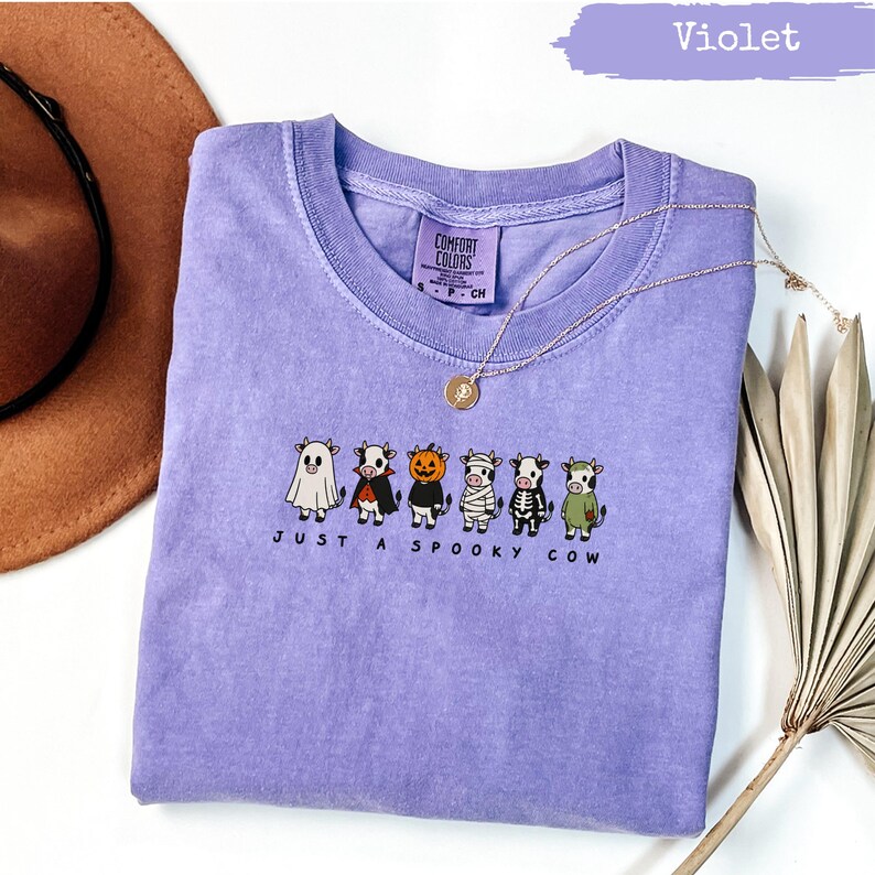 Purple t-shirt with "Just a Spooky Cow" text and Halloween-themed cows.