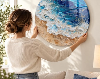 May include: A circular wall art piece featuring a textured oil painting of an ocean shoreline. The artwork displays thick impasto brushstrokes in shades of deep blue, turquoise, and white, depicting crashing waves meeting a sandy beige beach.