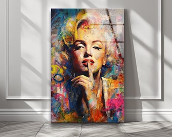 May include: A rectangular wall art print featuring a vibrant, multi-colored abstract portrait of Marilyn Monroe. The image displays her with a finger pressed to her lips in a hush gesture, rendered in bold splashes of yellow, blue, red, and pink.