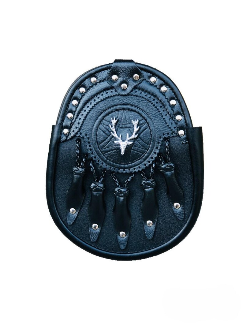 Puede incluir: Sporran de cuero negro con un emblema de cabeza de ciervo plateado y costuras decorativas. El sporran tiene flecos y est&aacute; adornado con tachuelas plateadas.
