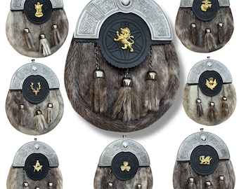 Könnte beinhalten: Eine Sammlung traditioneller schottischer Sporrane. Jeder Sporran hat einen Pelzkörper, einen dekorativen Metall-Cantle und eine Lederfront mit einem einzigartigen Emblem. Quasten und Kettendetails runden das Design ab. Die Embleme umfassen einen Löwen, einen Hirsch und andere Symbole.