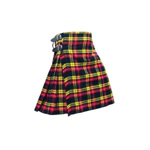 May include: A traditional Scottish kilt in a vibrant tartan pattern of red, yellow, and black. The kilt features leather straps with silver buckles for closure. The pleated design is visible, showcasing the fabric's woven texture.