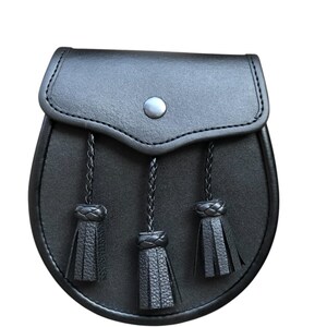 May include: A black leather sporran with three tassels. The sporran has a flap with a button closure.