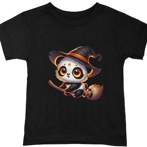 May include: A black t-shirt with a cute cartoon panda wearing a witch hat and riding a broomstick. The panda has black and white fur and big, round eyes.