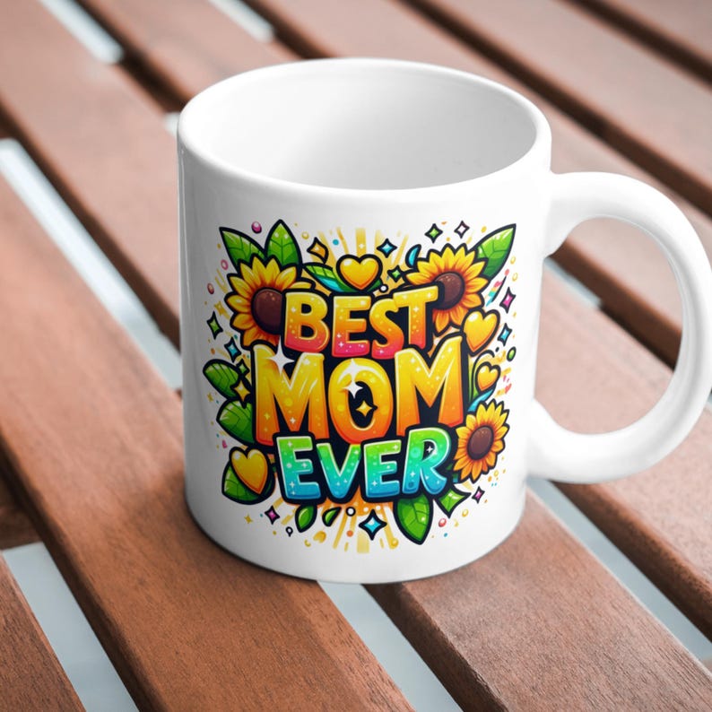 以下が含まれることがあります： 白いセラミック製のマグカップで、ひまわり、ハート、そして「Best Mom Ever」という文字が描かれたカラフルなグラフィックデザインが施されています。