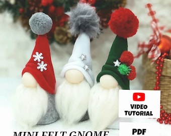 May include: Three felt gnome ornaments with different colored hats. The gnomes are wearing red, green, and white hats with pom-poms. The gnomes have white beards and are sitting on a white surface. The image includes the text "MINI FELT GNOME", "VIDEO TUTORIAL", and "PDF PATTERN".