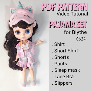 Può includere: Una bambola Blythe con un pigiama rosa, composto da camicia, pantaloncini, pantaloni, mascherina per dormire, reggiseno in pizzo e pantofole. La mascherina per dormire è a tema unicorno. Il testo "PDF PATTERN" e "PAJAMA SET for Blythe Ob24" è visibile.