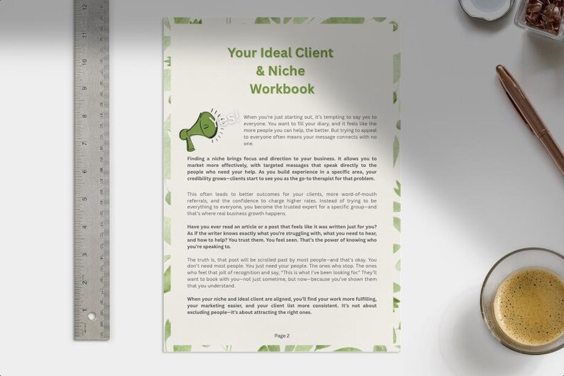 May include: A workbook titled "Your Ideal Client & Niche Workbook" with green watercolor accents. A metal ruler is on the left. A cup of coffee, a pen, and other items are on a white surface.