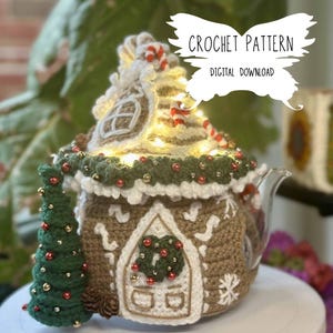 Puede incluir: Patrón de crochet para una funda de tetera de jengibre. La funda es marrón y blanca con detalles rojos y verdes. Incluye un pequeño árbol de Navidad de crochet y el texto "CROCHET PATTERN DIGITAL DOWNLOAD".