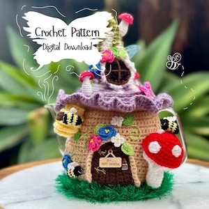 May include: Crochet pattern for a whimsical teapot cozy shaped like a fairy house with a purple roof, brown walls, a red mushroom, and bees. The sign on the door reads "Shh...baby sleeping".