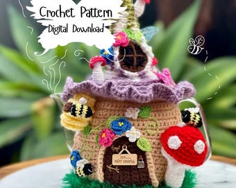 May include: Crochet pattern for a whimsical teapot cozy shaped like a fairy house with a purple roof, brown walls, a red mushroom, and bees. The sign on the door reads "Shh...baby sleeping".