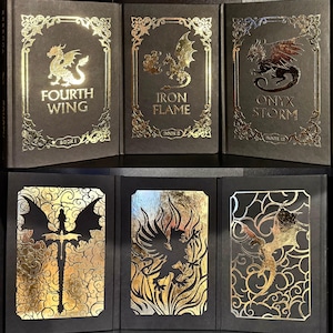 May include: Three black hardcover books with gold foil accents. The books are titled "Fourth Wing", "Iron Flame", and "Onyx Storm". The books are part of a series and are numbered 1, 2, and 3 respectively.