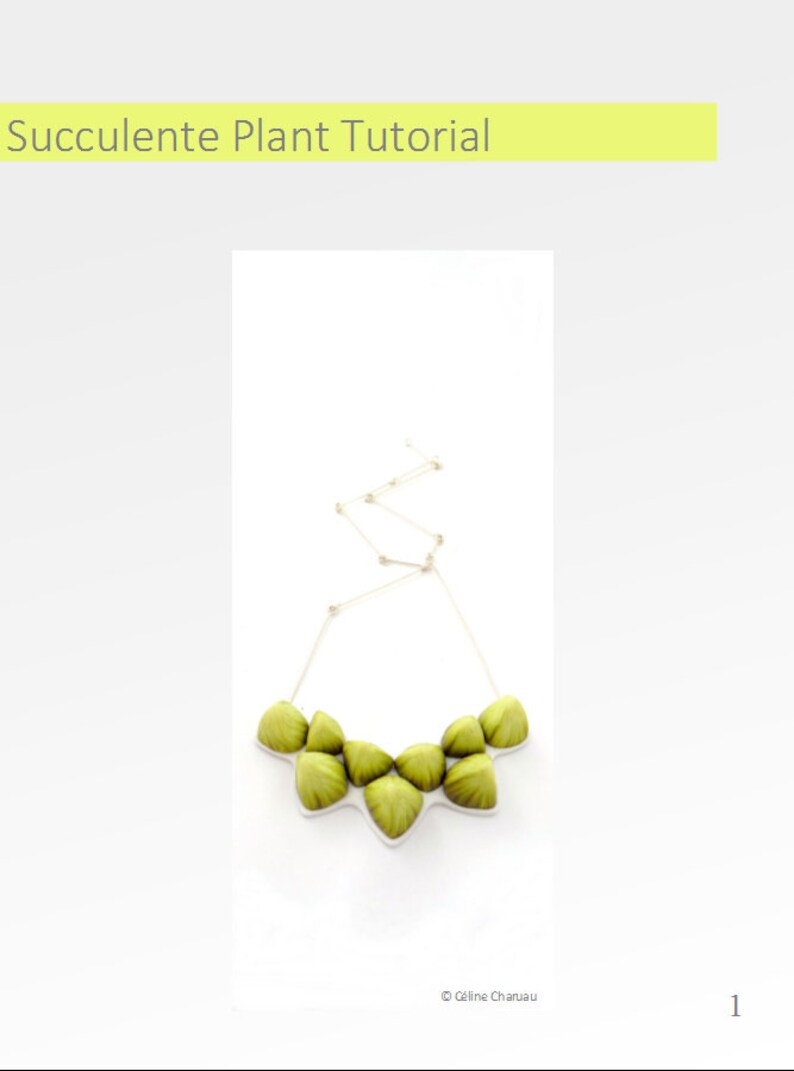 May include: A green succulent plant necklace with a silver chain. The necklace is made of several small, green succulent plants that are arranged in a circle. The chain is attached to the back of the necklace.