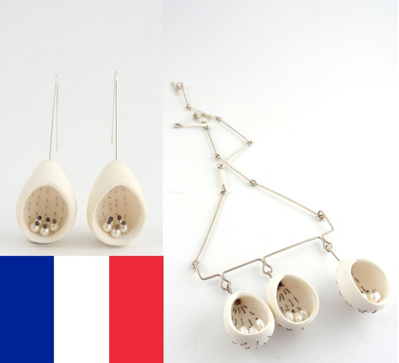 May include: A set of white ceramic earrings and a necklace with three pendant charms. Each piece features a small, open-topped basket filled with white pearls.