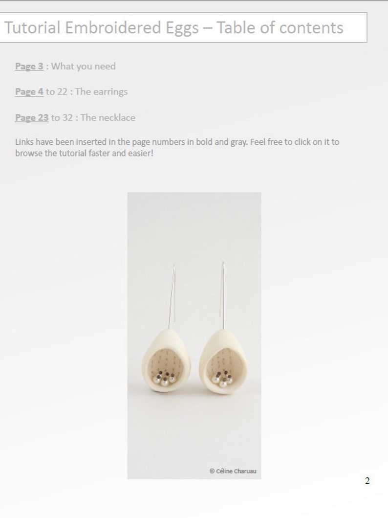 May include: A pair of white ceramic earrings shaped like eggs with small silver beads inside. The earrings are hanging from silver hooks.