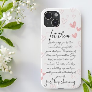 Pu&ograve; includere: Una custodia per iPhone bianca con un design rosa e bianco. La custodia presenta una citazione che recita: "Lascia che ti giudichino. Lascia che ti fraintendano. Lascia che parlino di te. Le opinioni degli altri non sono il tuo problema. Rimani gentile, impegnato nell'amore e autentico. Non importa cosa facciano o dicano, non dubitare mai del tuo valore o della bellezza della tua verit&agrave;. Continua a brillare."