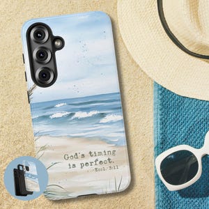 May include: A light blue phone case featuring a beach scene with ocean waves and sand. The case has the text "God's timing is perfect." and a small inset image of the case. A straw hat and sunglasses are next to the case.