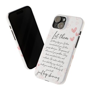 Pu&ograve; includere: Una custodia per iPhone bianca con un design a forma di cuore rosa e bianco. La custodia presenta una citazione che recita: "Lascia che ti giudichino. Lascia che ti fraintendano. Lascia che parlino di te. Le opinioni degli altri non sono il tuo problema. Rimani gentile, impegnato nell'amore e autentico. Non importa cosa facciano o cosa dicano, non dubitare del tuo valore o della bellezza della tua verit&agrave;. Continua a brillare."