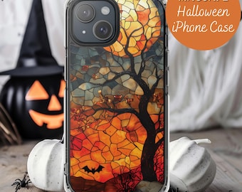 May include: Clear iPhone case with a Halloween-themed design. The case features a stained-glass style image of a tree, a full moon, and a bat. The text "MAGSAFE Halloween iPhone Case" is in an orange circle.