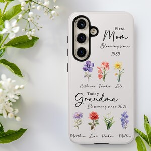May include: White phone case with a floral design and the words "First Mom Blooming since 1989" and "Today Grandma Blossoming since 2021". The case features a camera and several colorful flower illustrations.