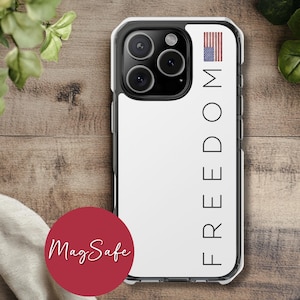 May include: A clear iPhone case with a white background and the word "FREEDOM" printed vertically in black. An American flag graphic is at the top. A red circle with the words "MagSafe" is at the bottom.