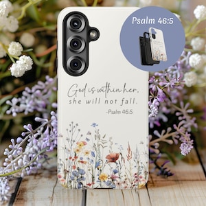 May include: A white phone case with a floral design and the text "God is within her, she will not fall. -Psalm 46:5." The case features a colorful wildflower pattern at the bottom. A secondary image shows the case in black and white.