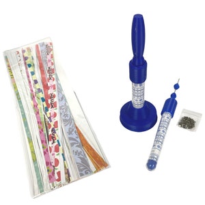 May include: A quilling kit featuring a blue quilling tool, a slotted pen, and a variety of colorful paper strips with floral and patterned designs. Also included are small metal findings in a clear bag.