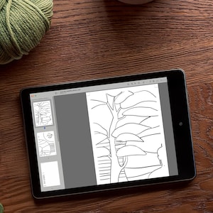 May include: A digital tablet displaying a black and white line drawing of a tree with branches and leaves. The tablet is on a wooden surface.