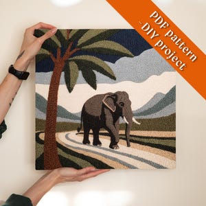 Peut inclure: Une œuvre d'art carrée et texturée représentant un éléphant sur un chemin, avec un arbre à gauche. L'arrière-plan comprend des montagnes et un ciel bleu foncé. L'œuvre d'art porte l'inscription "PDF pattern - DIY project".
