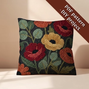 May include: Square decorative pillow with a floral design. The pillow features a dark background with embroidered flowers in shades of red, orange, and yellow, with green leaves. The text "PDF pattern - DIY project" is on a brown diagonal banner.