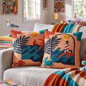 May include: Two square throw pillows featuring textured embroidery on a peach background. One pillow displays a sailboat, waves, and a fish. The other pillow depicts a lighthouse, waves, a crab, and a sun. Both pillows have dark blue palm leaves.