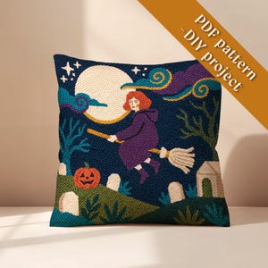 May include: A square throw pillow featuring a needlepoint design of a person with red hair flying on a broomstick against a dark blue night sky with a large moon, a jack-o'-lantern, and tombstones. The text PDF pattern - DIY project is visible.