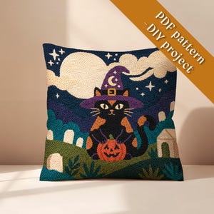 May include: A square throw pillow featuring a punch needle design of a black cat wearing a purple witch hat and holding an orange jack-o'-lantern. The background shows a night sky with a large moon, clouds, stars, and a graveyard. Text reads PDF pattern - DIY project.