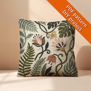 Puede incluir: Cojín cuadrado decorativo con un diseño floral bordado. Presenta flores rosas, amarillas y verdes, con tallos y hojas verdes oscuros y negros, sobre un fondo crema. El texto "PDF pattern - DIY project" está incluido.